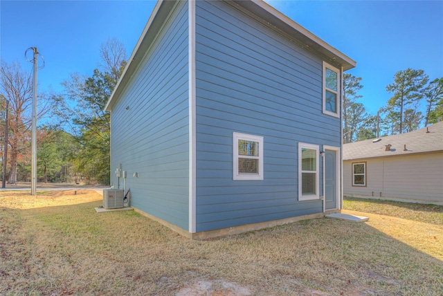 view of property exterior featuring central AC and a lawn