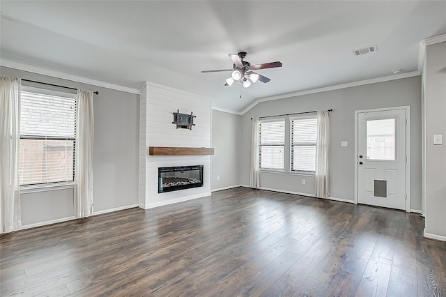 unfurnished living room with crown molding, a large fireplace, ceiling fan, and dark hardwood / wood-style flooring