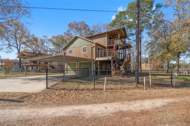 1382 Indian Hill Blvd, Livingston, TX 77351 - view of front of home with stairway, concrete driveway, a wooden deck, fence private yard, and a garage