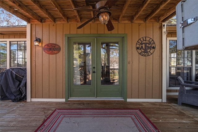 property entrance featuring french doors, ceiling fan, and a wooden deck