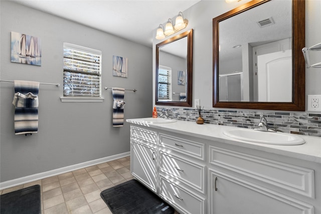 bathroom featuring tasteful backsplash, vanity, tile patterned flooring, and walk in shower