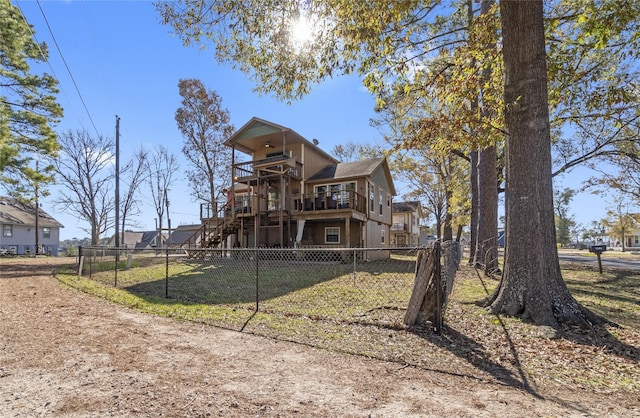 1382 Indian Hill Blvd, Livingston, TX 77351 - back of property featuring a lawn, a ceiling fan, a deck, fence private yard, and stairs