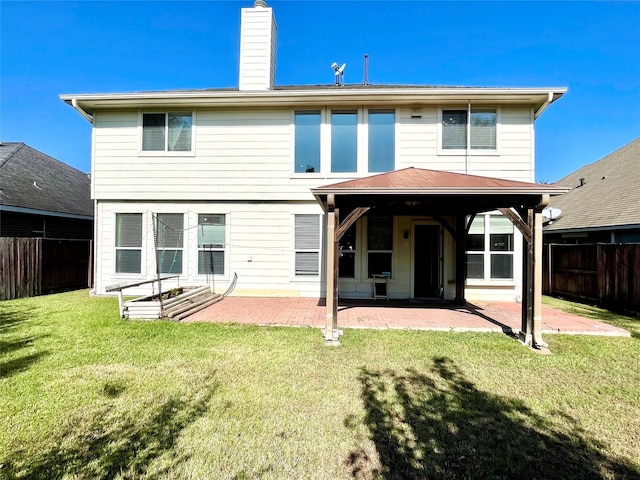 rear view of house featuring a yard, a chimney, a patio area, and fence private yard