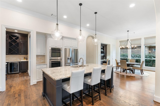 kitchen featuring a spacious island, decorative light fixtures, stainless steel appliances, and white cabinets