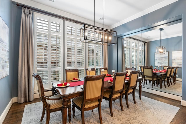 dining room with crown molding, dark hardwood / wood-style floors, and an inviting chandelier