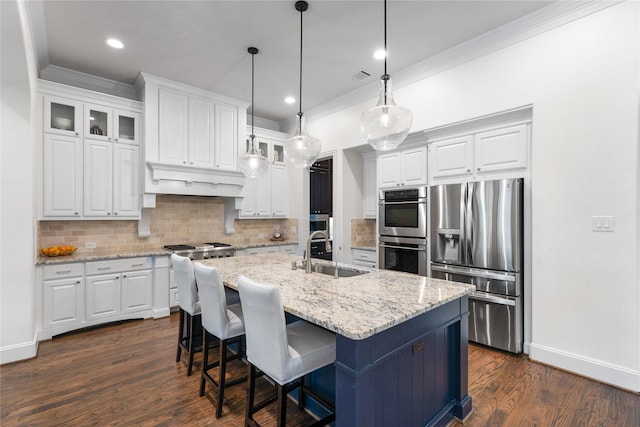 kitchen with sink, stainless steel appliances, light stone countertops, a kitchen island with sink, and white cabinets