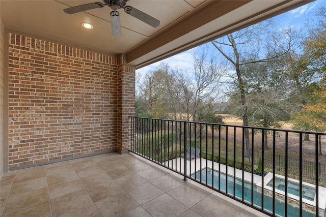 balcony featuring an in ground hot tub, ceiling fan, and a patio area