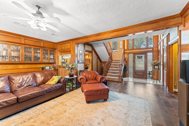 living room featuring lofted ceiling, ceiling fan, dark hardwood / wood-style floors, a textured ceiling, and wood walls