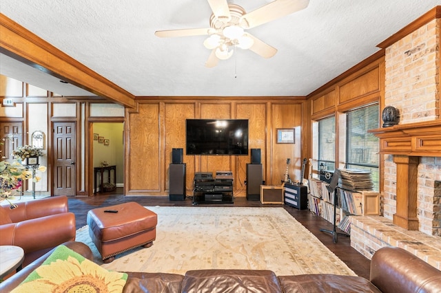 living room featuring ceiling fan, dark hardwood / wood-style flooring, a brick fireplace, and a textured ceiling