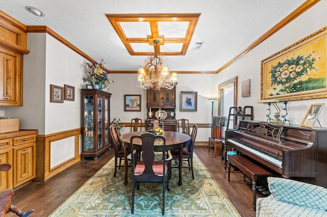 dining room featuring dark wood-type flooring, crown molding, a textured ceiling, and a notable chandelier