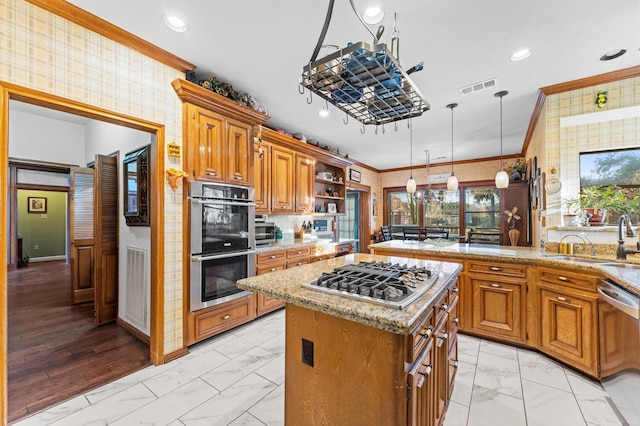 kitchen featuring ornamental molding, stainless steel appliances, a center island, and sink