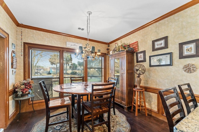 dining space featuring crown molding, dark hardwood / wood-style floors, and a chandelier