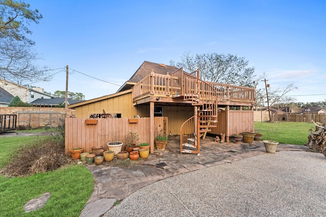 back of house featuring a lawn and a deck