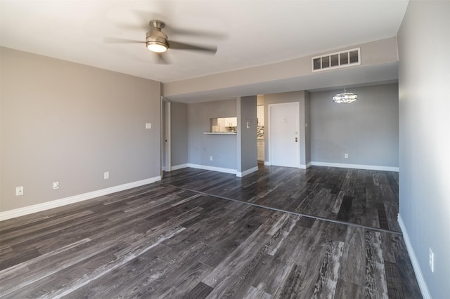 unfurnished living room with dark hardwood / wood-style flooring and ceiling fan with notable chandelier