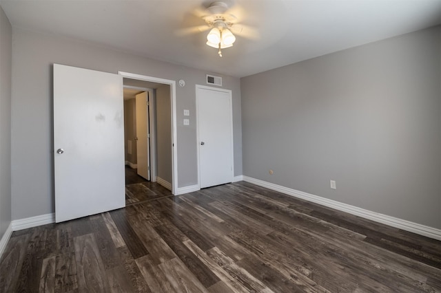 unfurnished bedroom featuring ceiling fan and dark hardwood / wood-style flooring