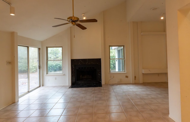 unfurnished living room with a high end fireplace, high vaulted ceiling, ceiling fan, and light tile patterned flooring