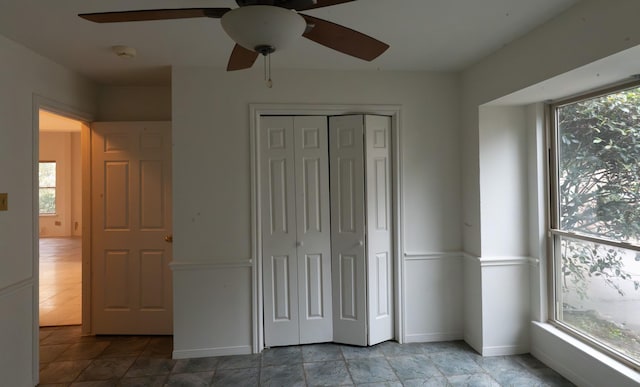 unfurnished bedroom featuring ceiling fan and a closet