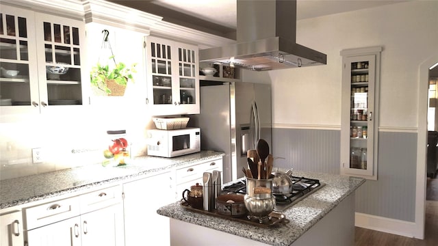 kitchen featuring stainless steel appliances, light stone countertops, white cabinets, island exhaust hood, and dark hardwood / wood-style flooring