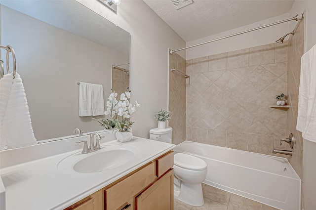 full bathroom featuring tiled shower / bath combo, vanity, a textured ceiling, tile patterned floors, and toilet