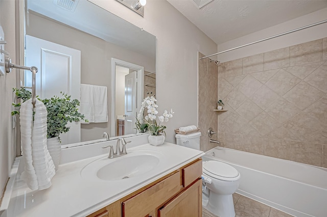 full bathroom featuring tiled shower / bath combo, vanity, tile patterned floors, and toilet