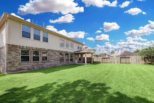 rear view of property with a yard