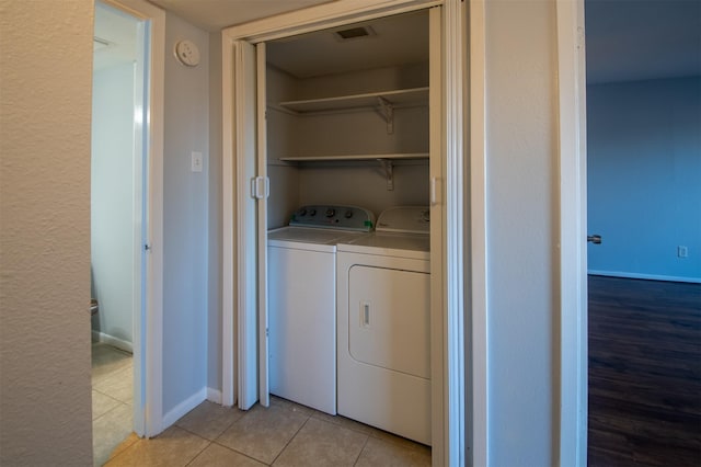 laundry area with light tile patterned flooring and separate washer and dryer