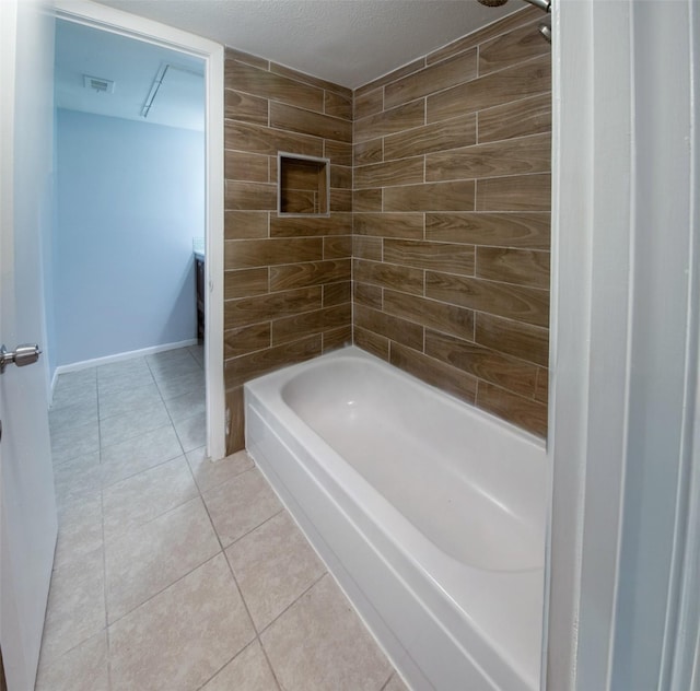 bathroom with tiled shower / bath, tile patterned flooring, and a textured ceiling