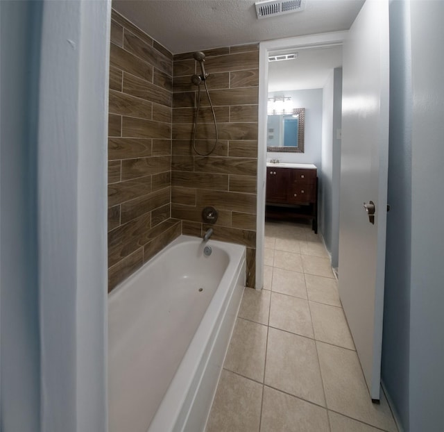 bathroom with tile patterned flooring, vanity, and tiled shower / bath combo