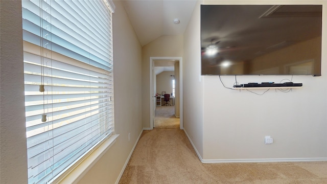 corridor featuring lofted ceiling and light carpet