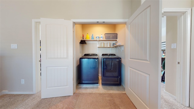 clothes washing area featuring independent washer and dryer and light carpet