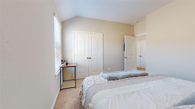 bedroom featuring light carpet, vaulted ceiling, and a closet