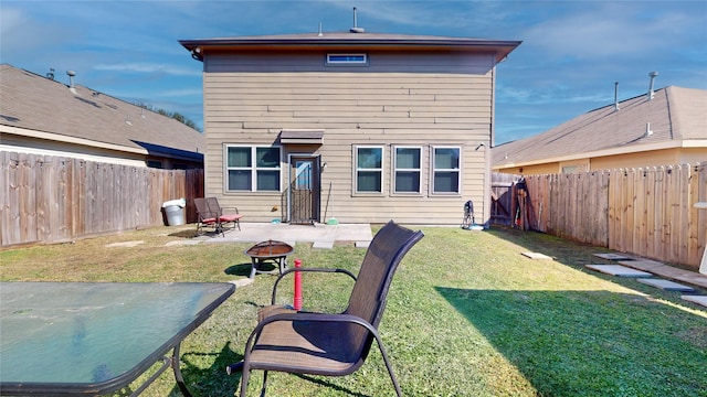 back of house with a yard, a patio area, and a fire pit