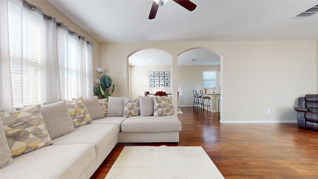 living room with dark wood-type flooring and ceiling fan