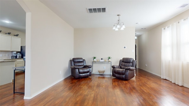 sitting room featuring an inviting chandelier and dark hardwood / wood-style floors