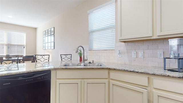 kitchen with sink, tasteful backsplash, kitchen peninsula, dishwasher, and light stone countertops