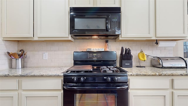 kitchen featuring light stone countertops, backsplash, black appliances, and white cabinets