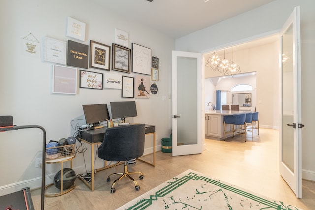 office with french doors, sink, and light hardwood / wood-style floors