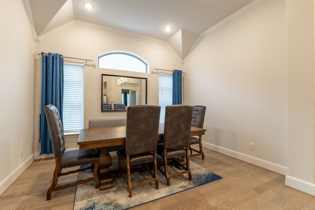 dining room with vaulted ceiling, crown molding, and light hardwood / wood-style floors