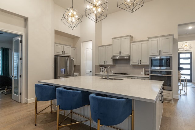 kitchen featuring a breakfast bar area, stainless steel appliances, and a center island with sink