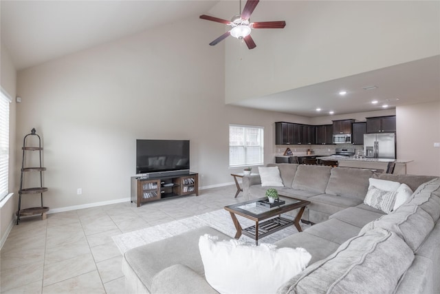 tiled living room featuring ceiling fan and high vaulted ceiling