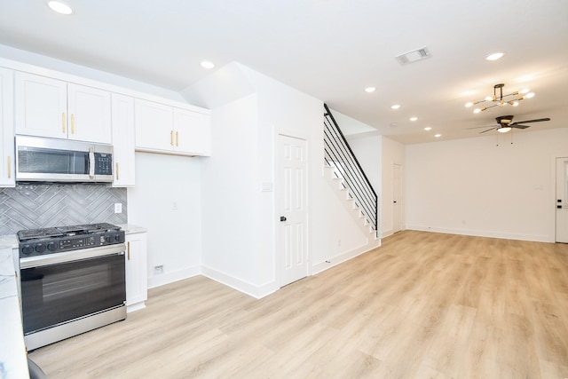 kitchen with white cabinetry, backsplash, light stone counters, range with gas cooktop, and light wood-type flooring