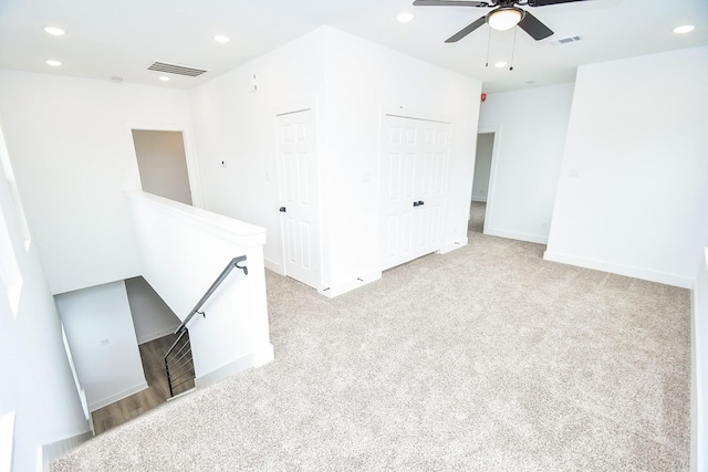 empty room featuring ceiling fan and light carpet