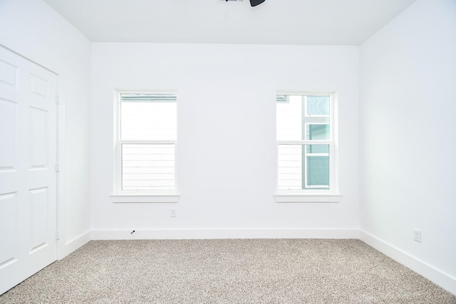 unfurnished room featuring plenty of natural light and carpet floors