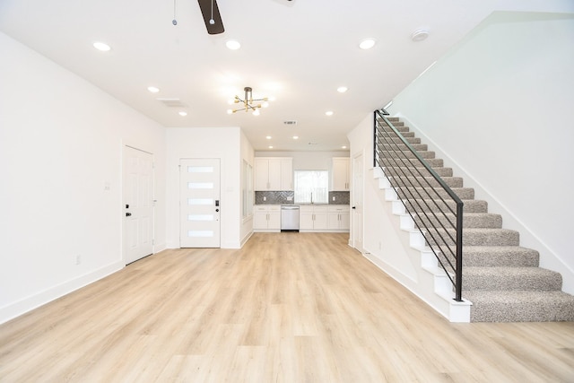 unfurnished living room with ceiling fan and light hardwood / wood-style floors