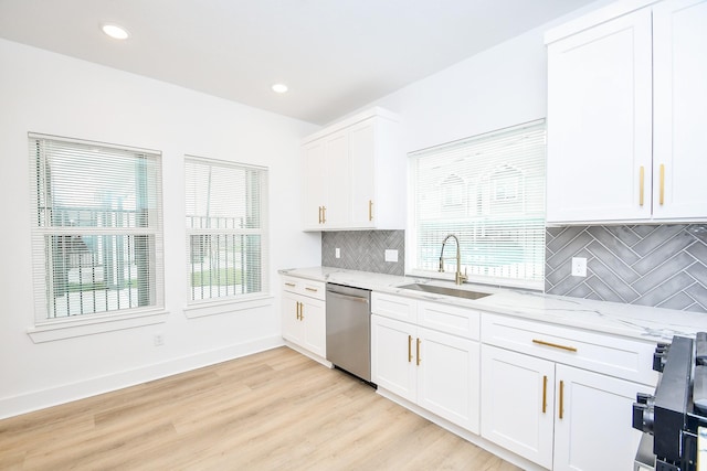 kitchen featuring sink, white cabinetry, stainless steel appliances, light stone counters, and light wood-type flooring