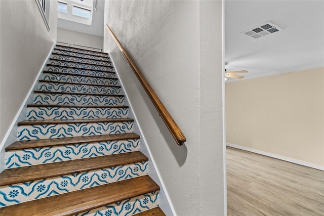 staircase featuring hardwood / wood-style floors and ceiling fan