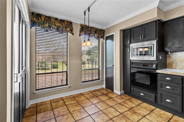 kitchen featuring stainless steel microwave, pendant lighting, crown molding, and oven