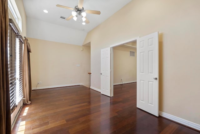 unfurnished room featuring lofted ceiling, plenty of natural light, dark hardwood / wood-style floors, and ceiling fan