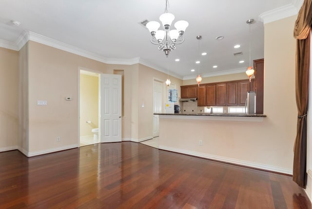 kitchen featuring stainless steel fridge, wood-type flooring, decorative light fixtures, and kitchen peninsula