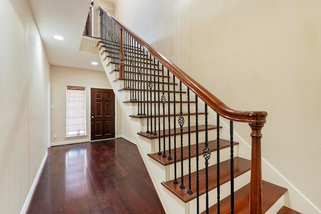 stairs with a towering ceiling and wood-type flooring